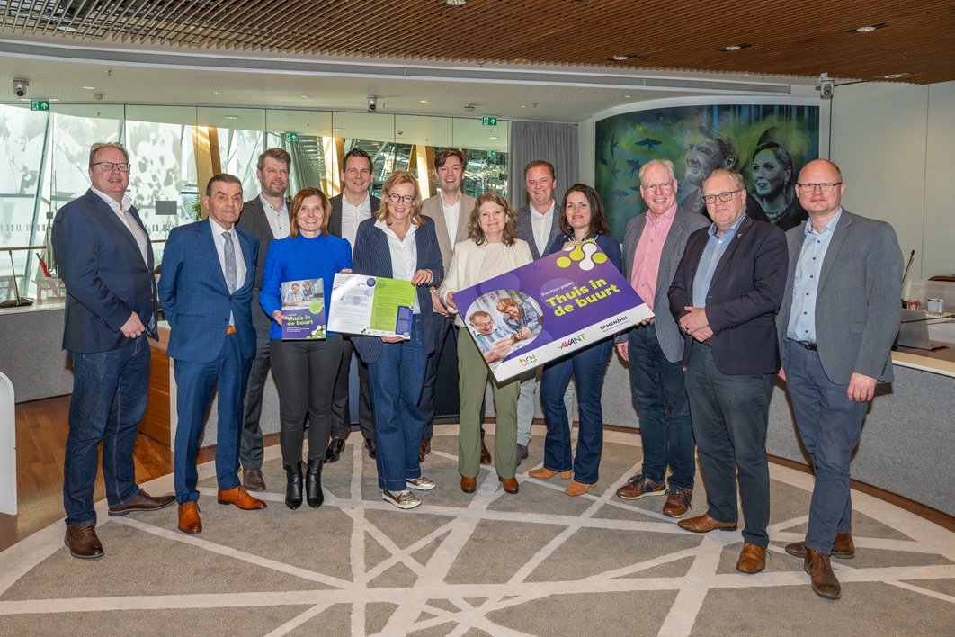 Op de foto: Joke van den Berg, voorzitter van de HRW-stuurgroep Wonen, Welzijn & Zorg en Astrid ter Horst, directeur-bestuurder van Radius onderdeel van SAMENZHN met het overhandigingsbord van het position paper Thuis in de buurt tijdens het aanbiedingsmoment bij de Commissie Wonen van Regio Holland Rijnland.